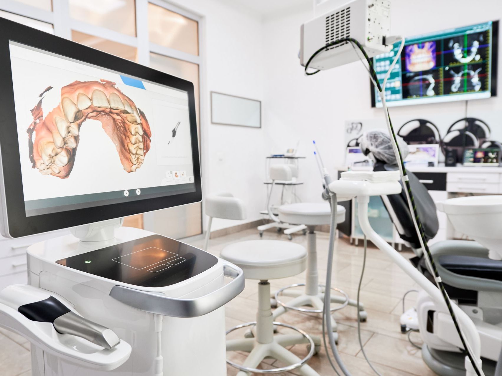 A dental office with a computer and a dental chair