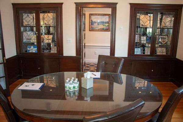 Dining room with round table, chairs, built-in cabinets, and doorway to a hallway.