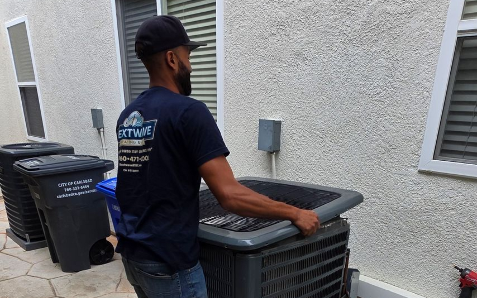 Professional HVAC technician performing a maintenance check on a residential unit.