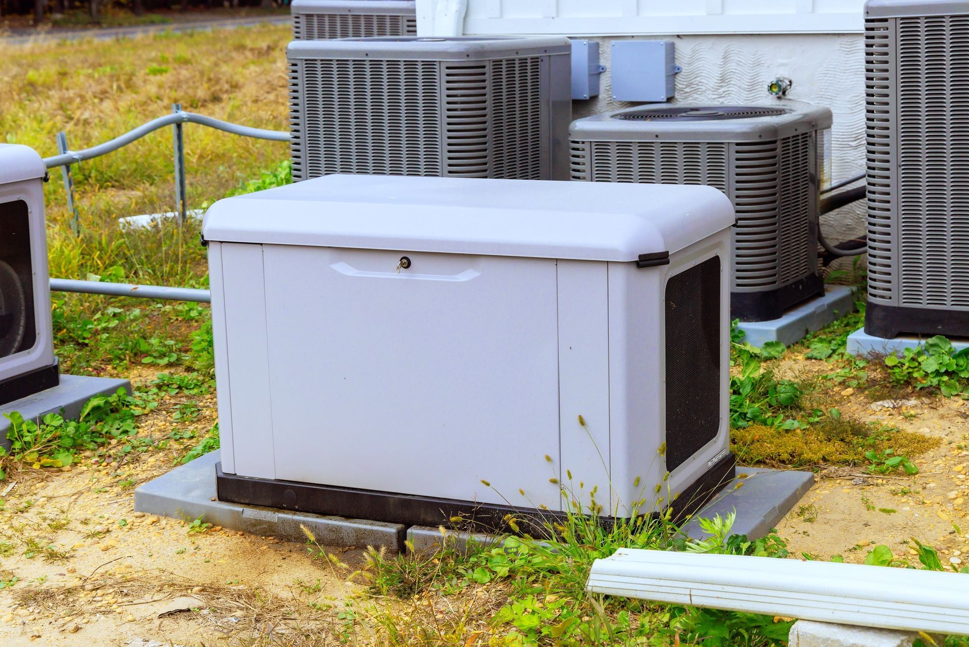 Generator surrounded by several air conditioning units outdoors.