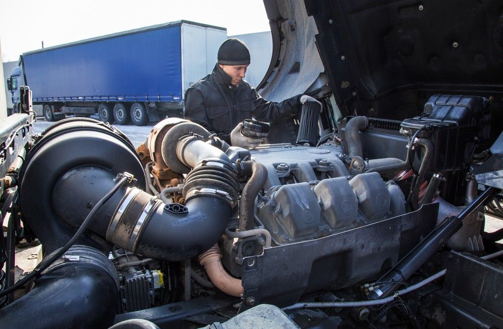 A Man is Working on the Engine of a Semi Truck — Drinnan's Diesel & Automotive Repairs In Boyne Island, QLD