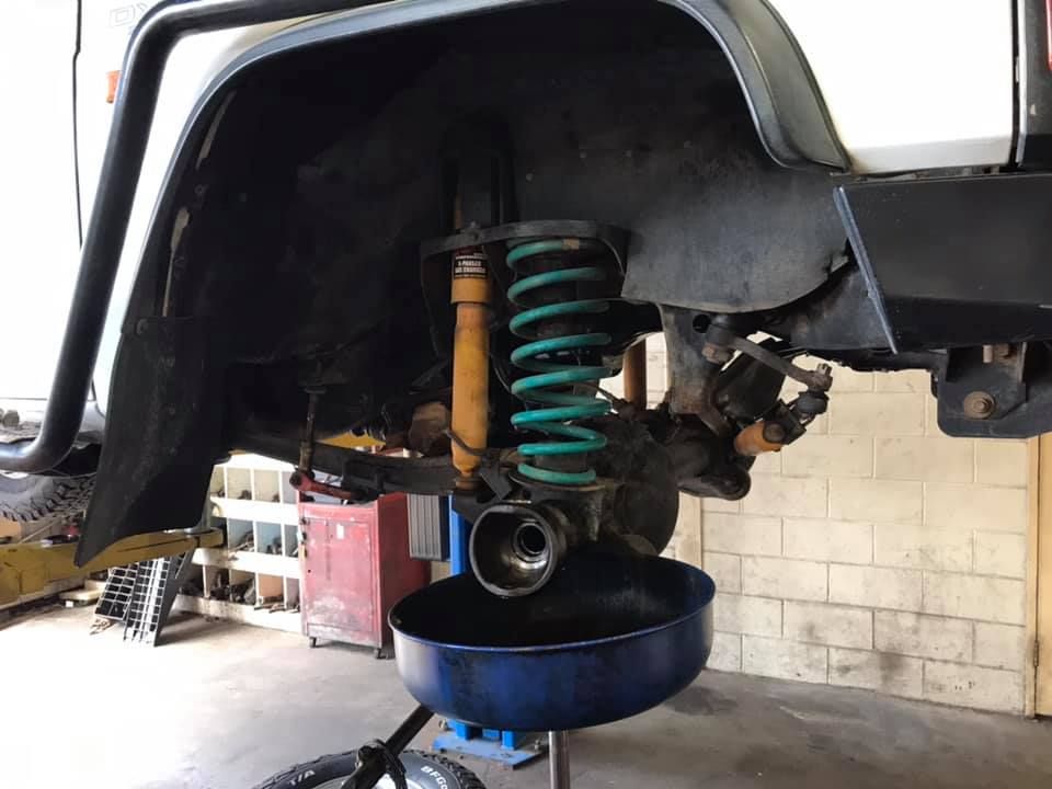 A Car is Being Worked on in a Garage With a Blue Bowl Filled With Oil — Drinnan's Diesel & Automotive Repairs In Gladstone Central, QLD