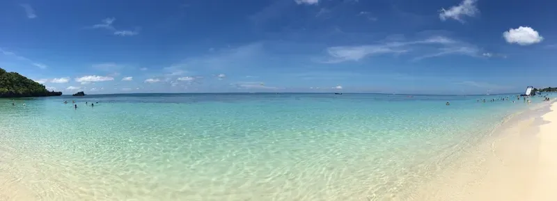 Una vista panorámica de una playa con gente nadando en el océano.