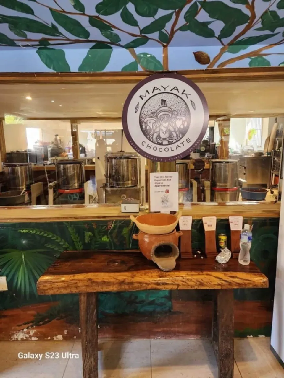 A wooden table with a sign on top of it in a restaurant.