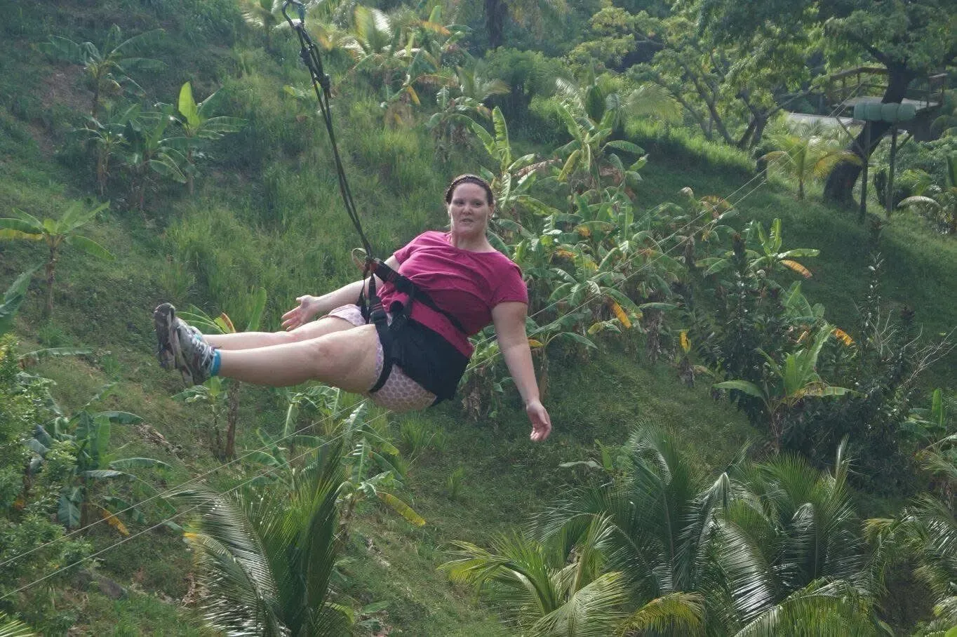Una mujer está volando por el aire en una tirolina en la jungla.