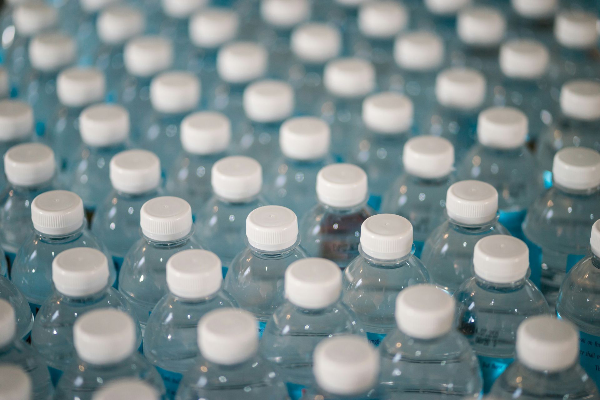 Botellas de detergente de plástico alineadas en estantes metálicos en el pasillo de una tienda.