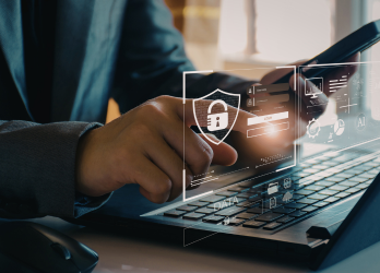 Person typing on a laptop with digital security icons overlayed on the screen