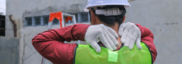 back of construction worker's head and shoulders with hands rubbing neck