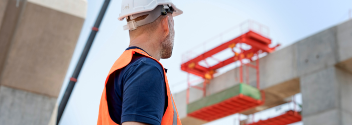 a safety professional surveys a construction lift at the top of a concrete building