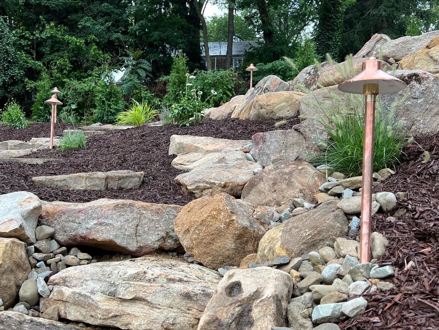 boulder feature hardscape with mulch and garden beds
