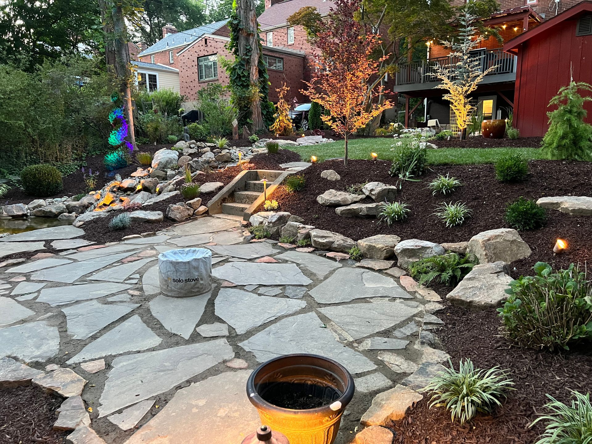 stone patio with firepit and garden beds