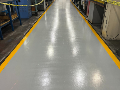 Gray factory floor with yellow safety lines.