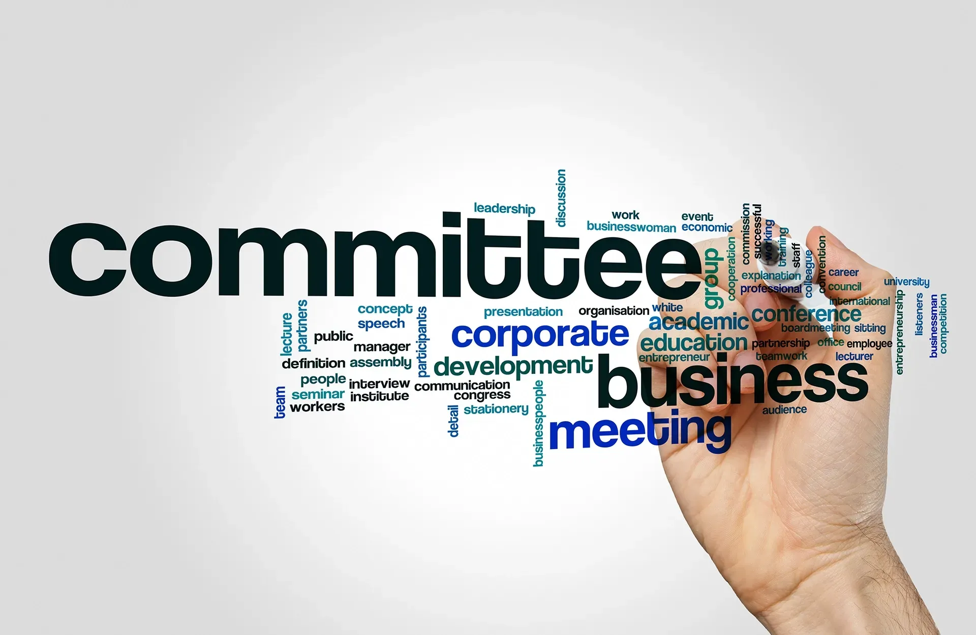 a hand is writing the word committee with a marker .