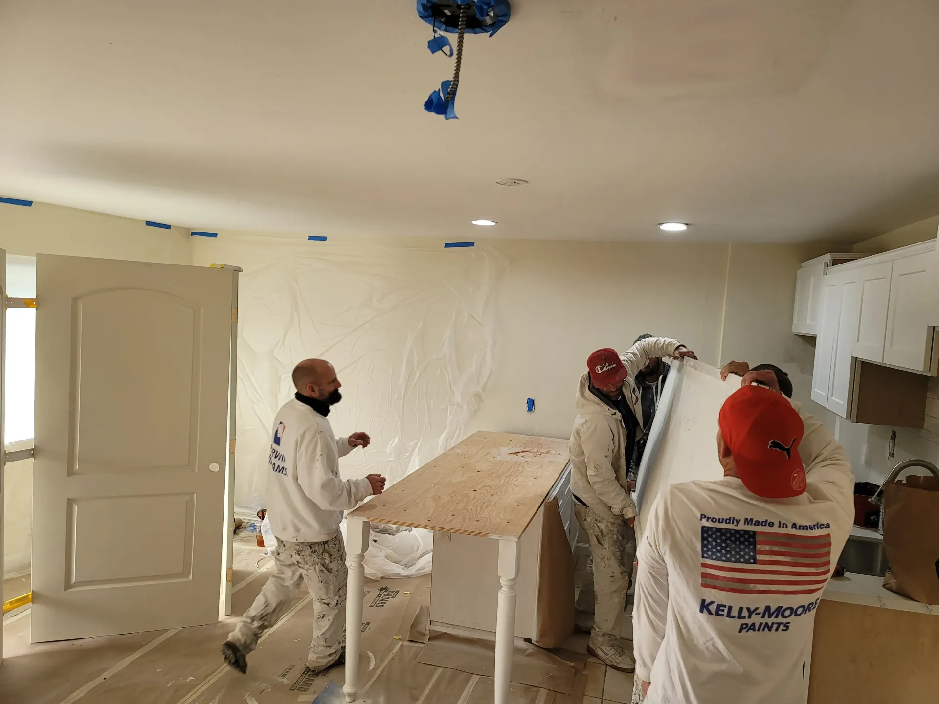 a group of men are standing around a table in a room .