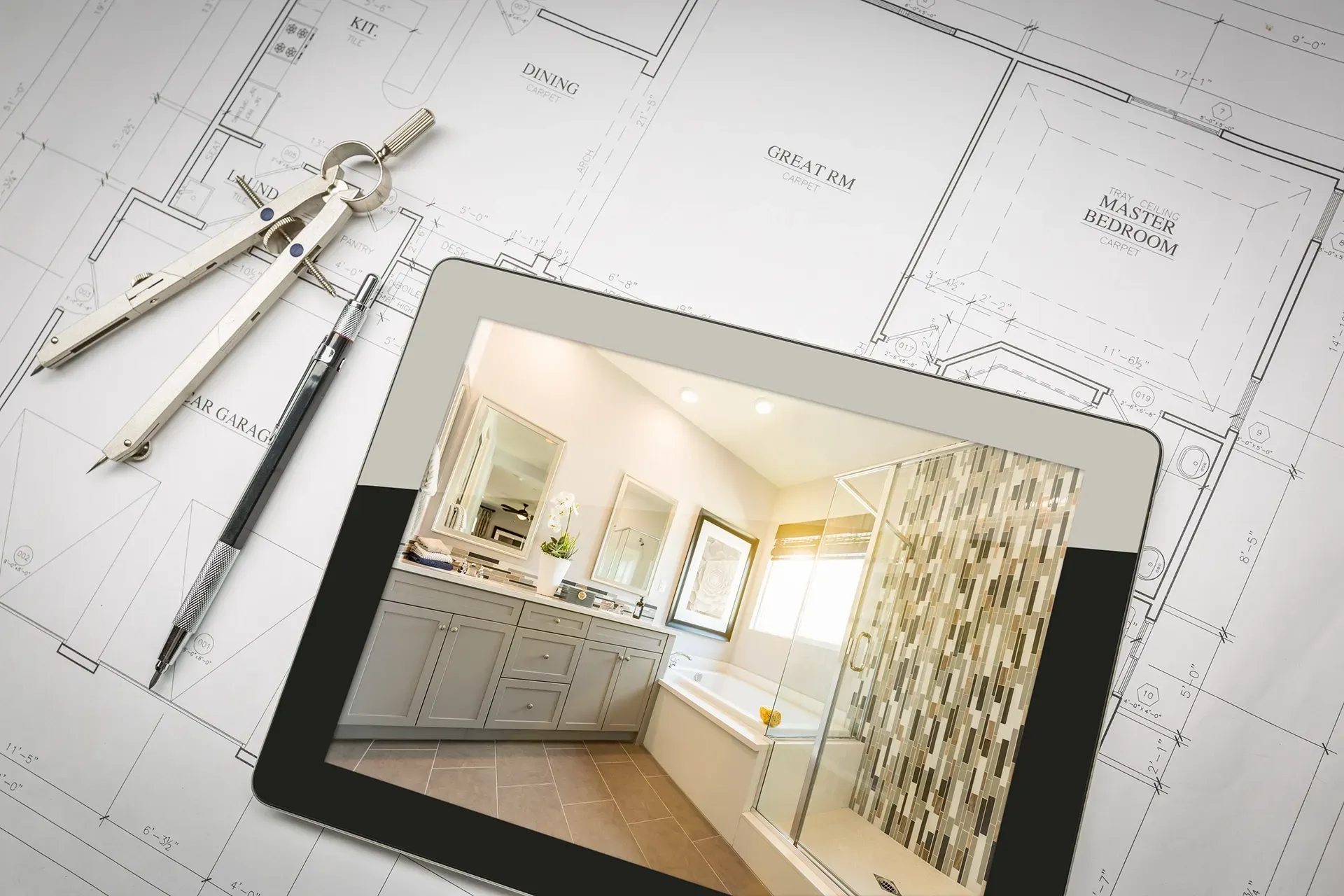 a tablet with a picture of a bathroom on it is sitting on top of a blueprint .