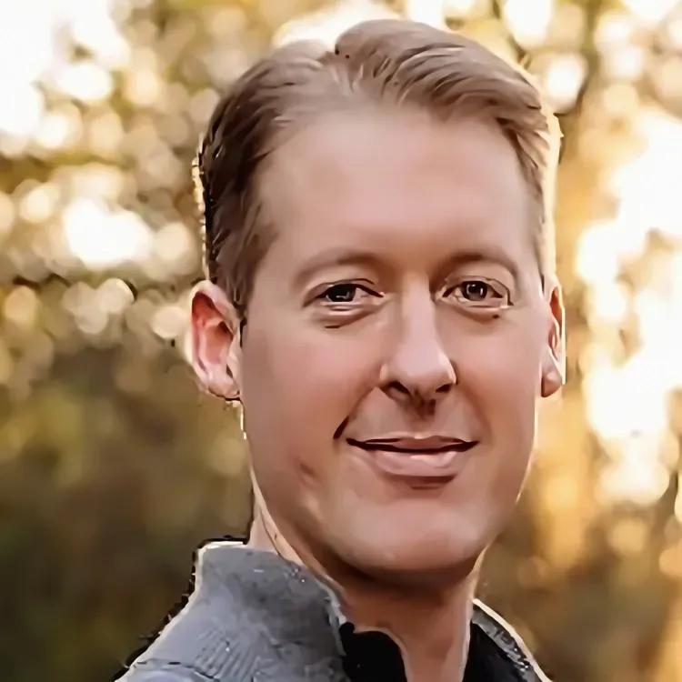 a close up of a man 's face with trees in the background .