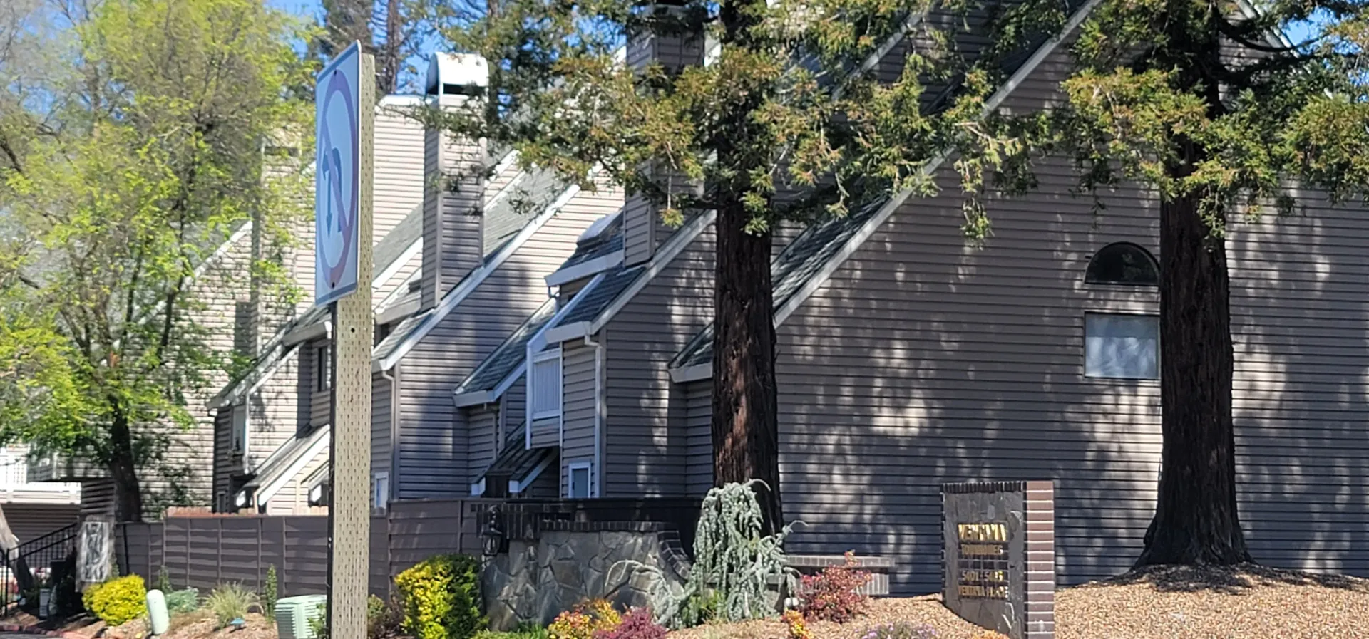 a row of houses with trees in front of them .