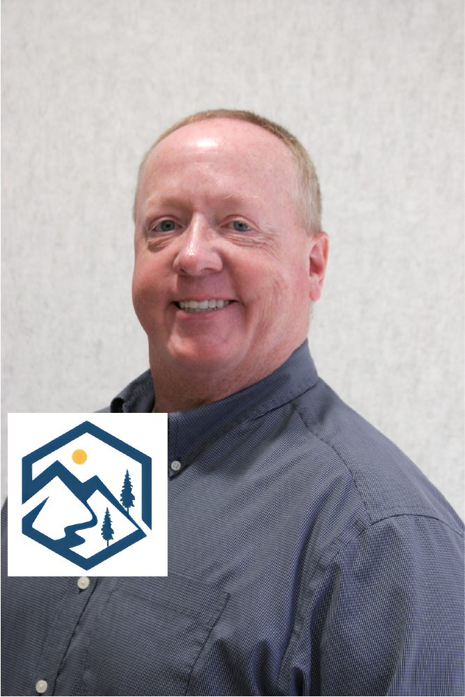 a man in a blue shirt is smiling with a Golden Sierra Insurance Services logo behind him