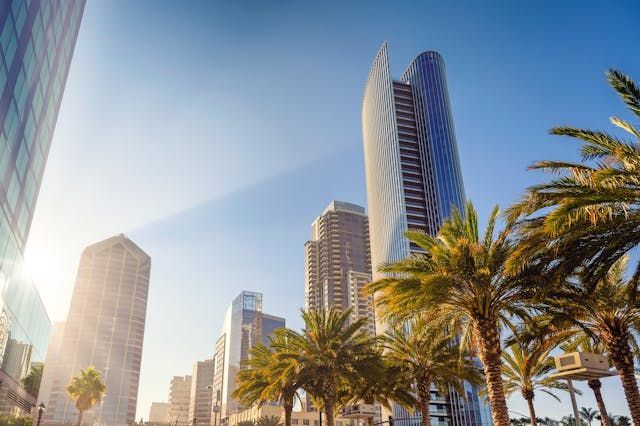 Skyscrapers and palm trees against and blue sky