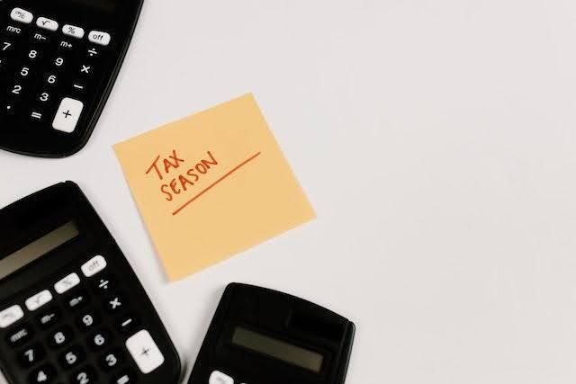 an orange sticky note with the words tax seasons written in red