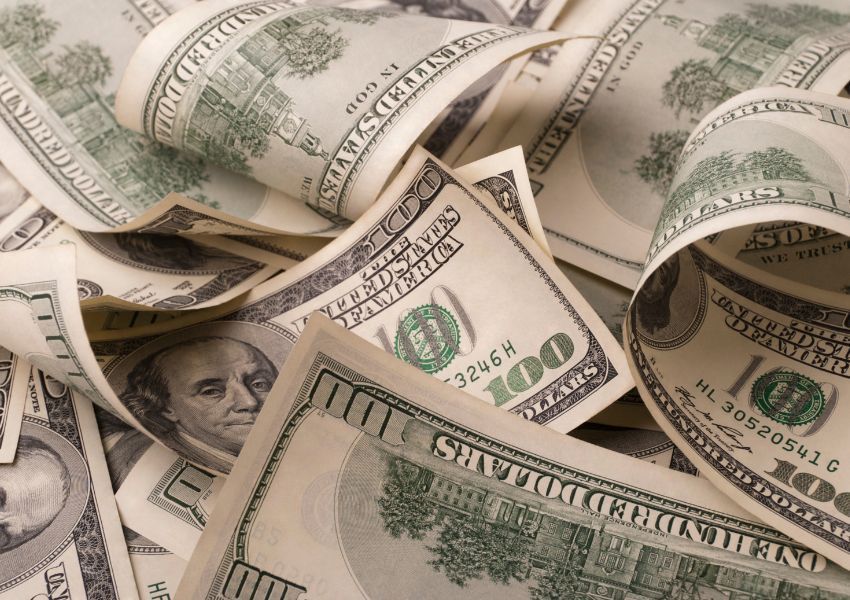a bunch of one hundred dollar bills spread out on top of each other