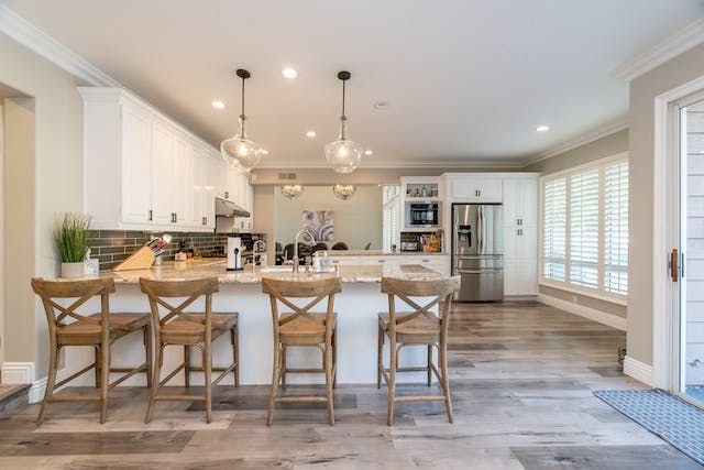 a kitchen with white cabinets and grey flooring