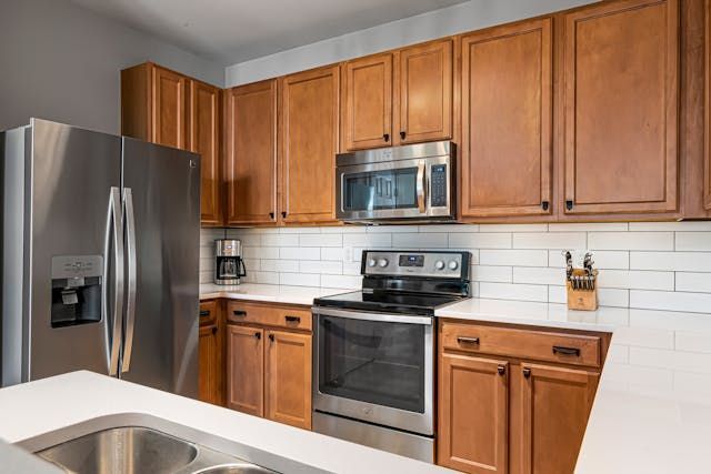 a kitchen with white walls, dark wood cabinets and modern appliances