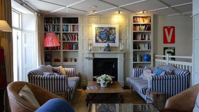 a living room with blue and white striped couches and a white built in book case