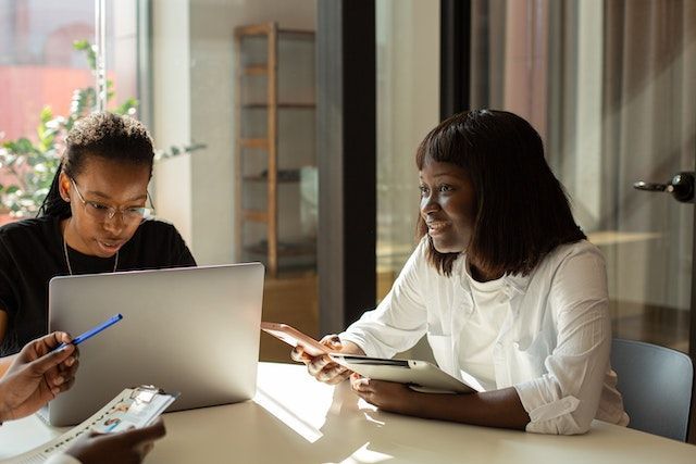 two property managers in a meeting looking at their computers and iPads