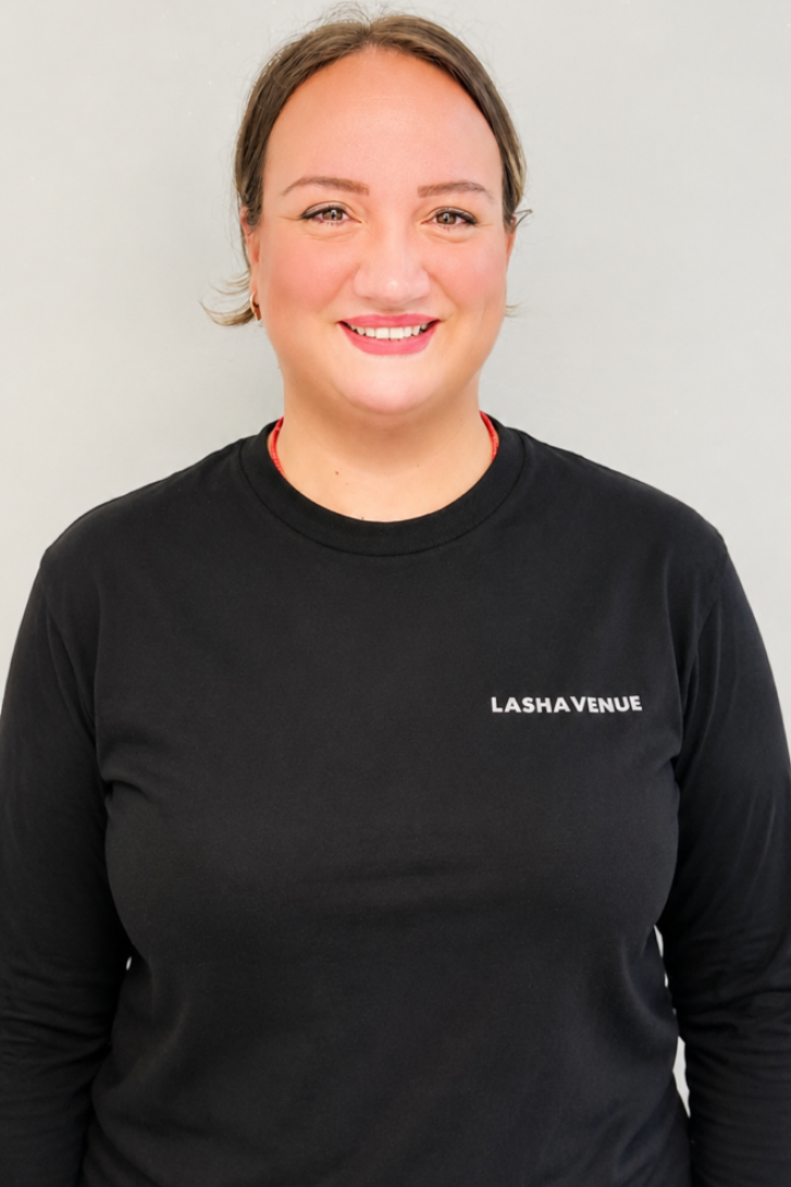 Woman with glasses smiling, wearing a white shirt with