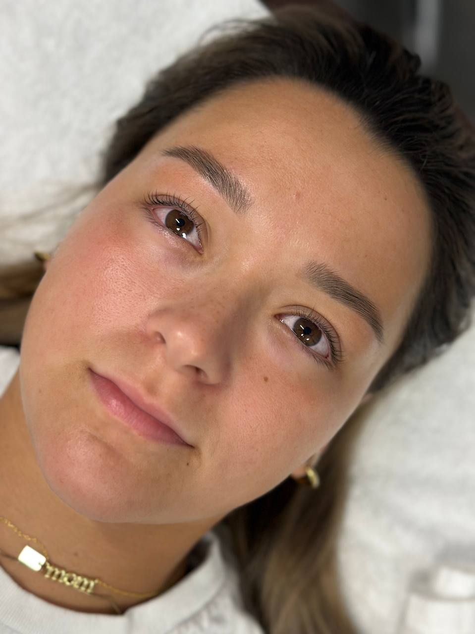 Woman with newly microbladed eyebrows and light freckles.