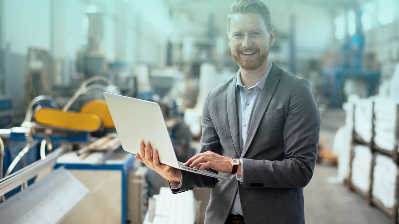 A business owner in a manufacturing plant, illustrating inventory and cost accounting services for manufacturers.
