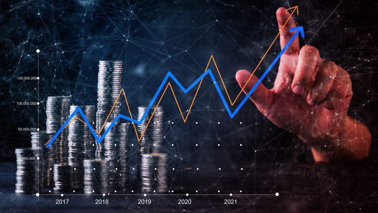 Hand drawing a rising blue chart over stacked silver coins on a dark financial background