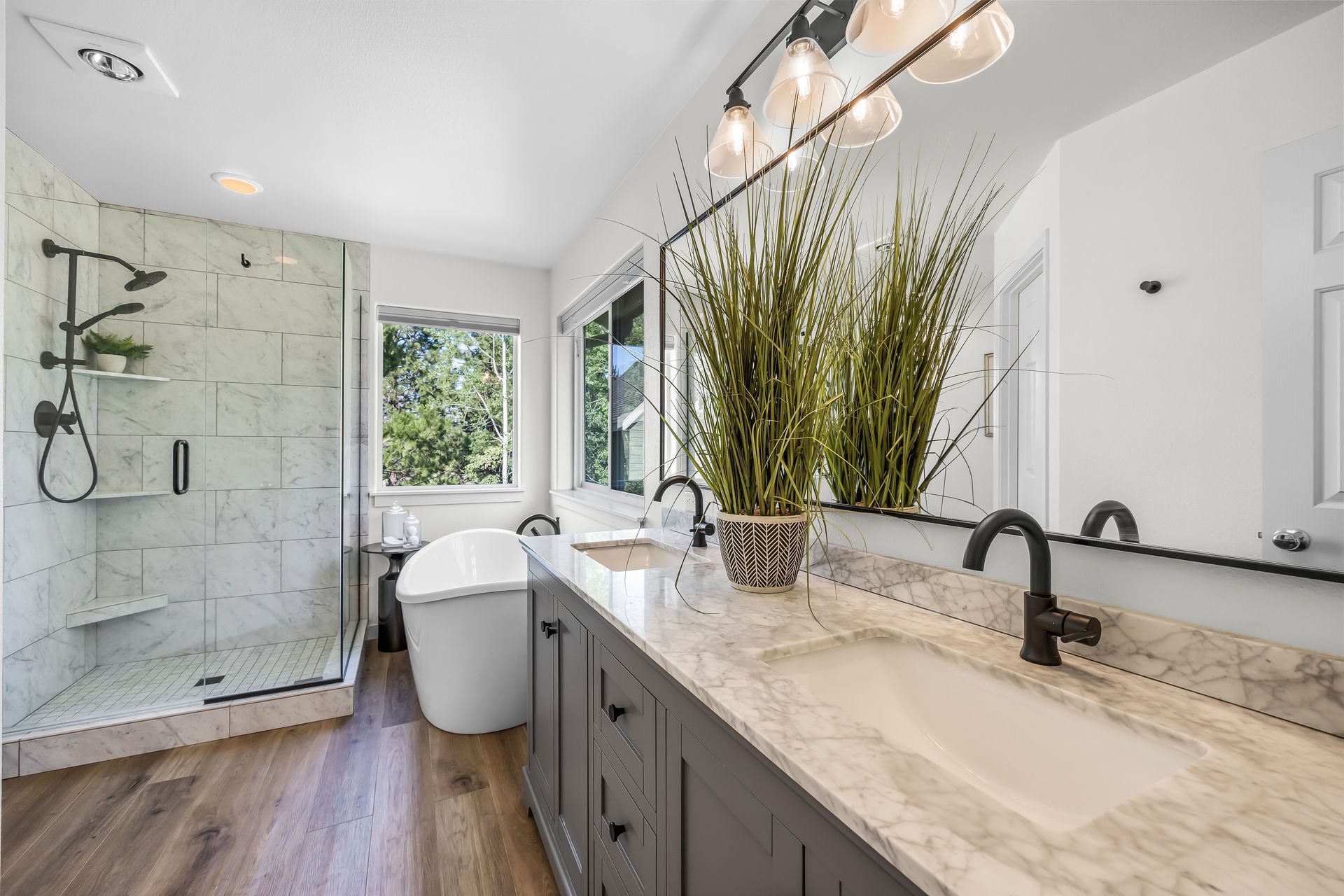 a bathroom with two sinks , a tub and a shower .