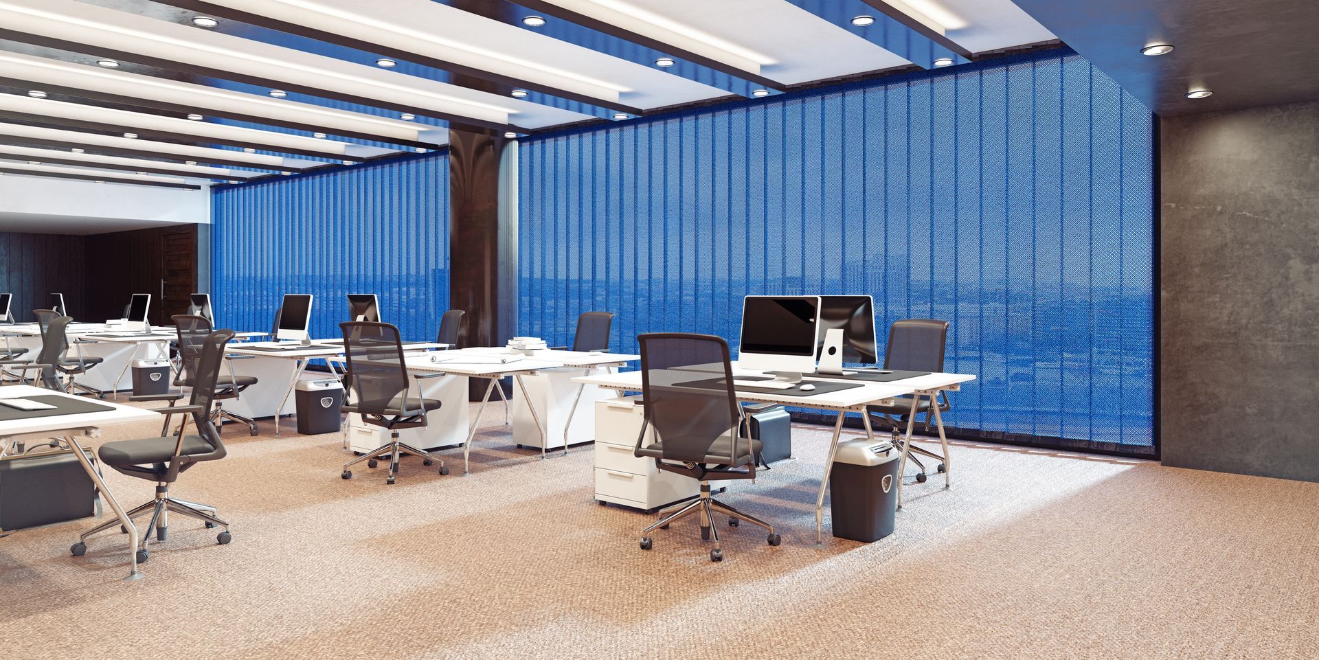 An empty office with lots of desks and chairs and a view of the ocean.