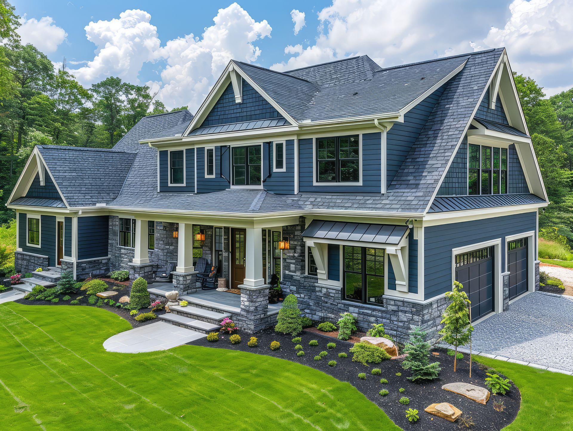 A large blue and white house with a large lawn in front of it.