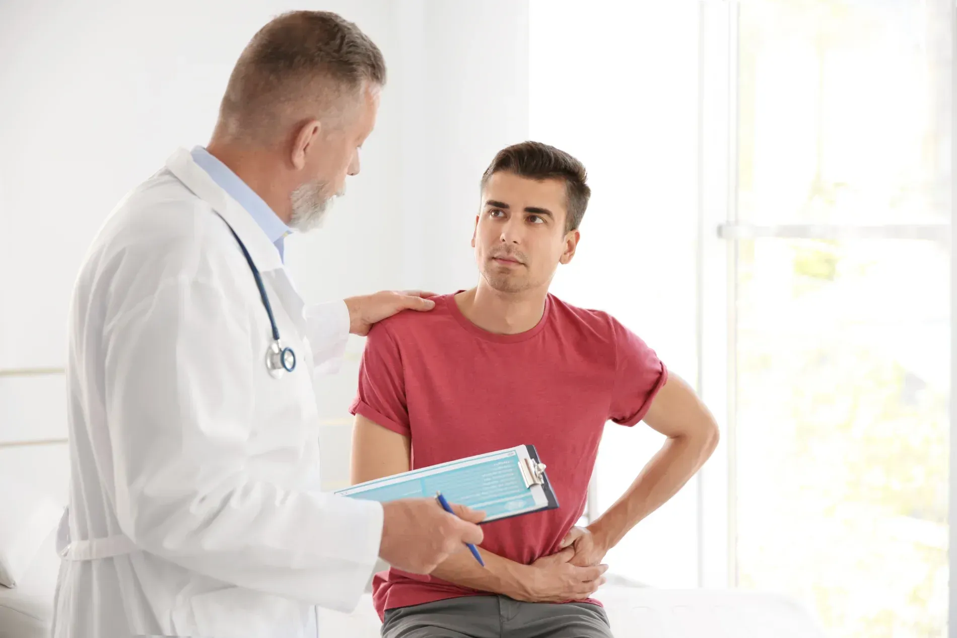 Doctor consoles patient with hand on shoulder in light-filled office  — Tewantin Medical Centre In Tewantin, QLD