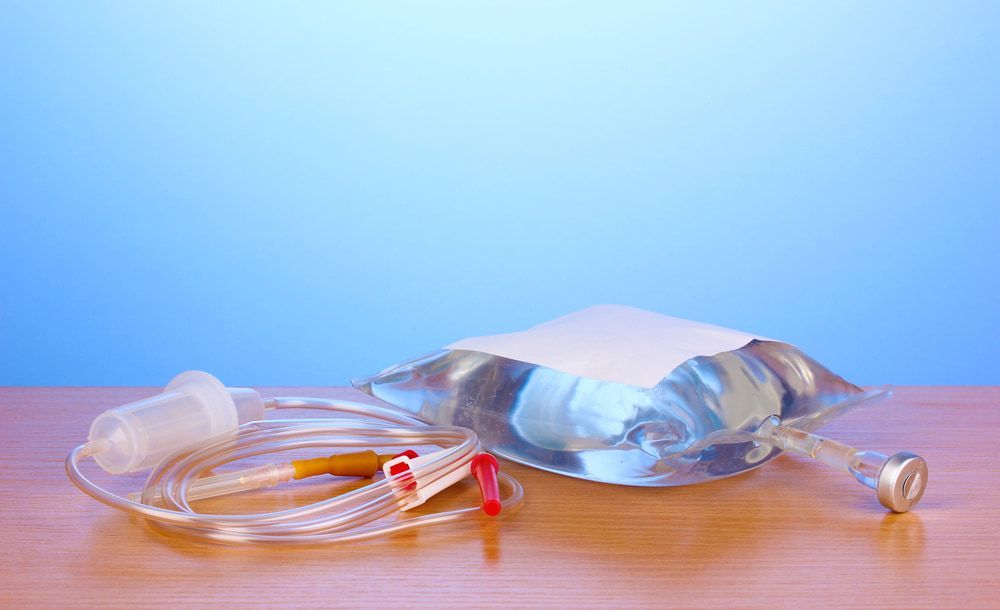 IV Bag With Tubing and Needle on a Wooden Surface, Blue Background — Tewantin Medical Centre In Tewantin, QLD