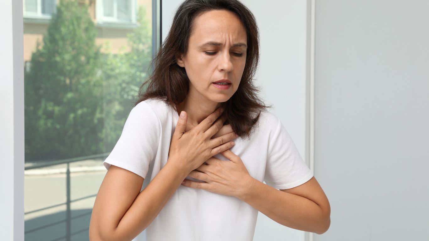 Woman Experiencing Chest Tightness, Holding Her Upper Chest With Both Hands — Tewantin Medical Centre In Tewantin, QLD