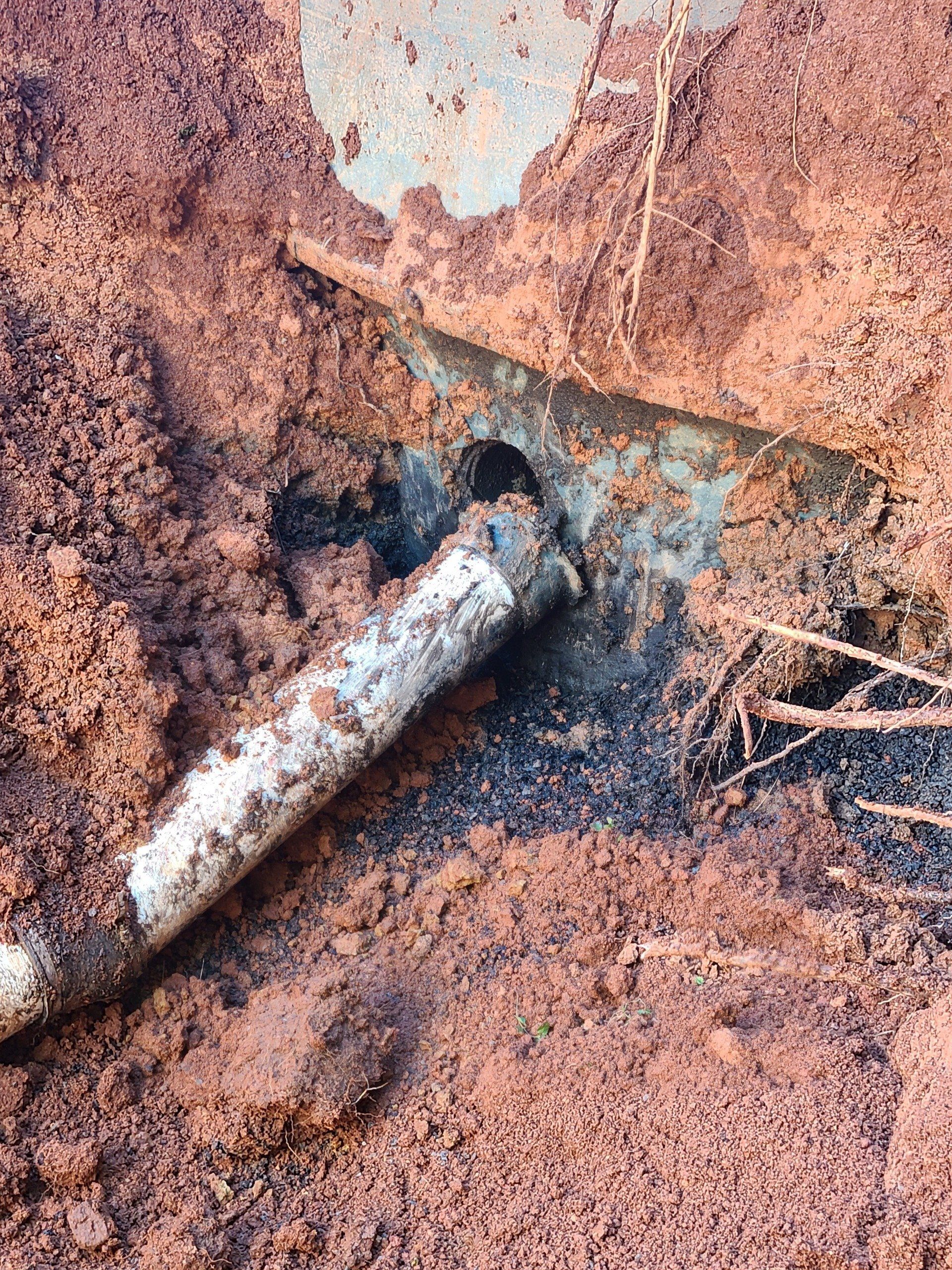 A rusty pipe is sticking out of the ground.
