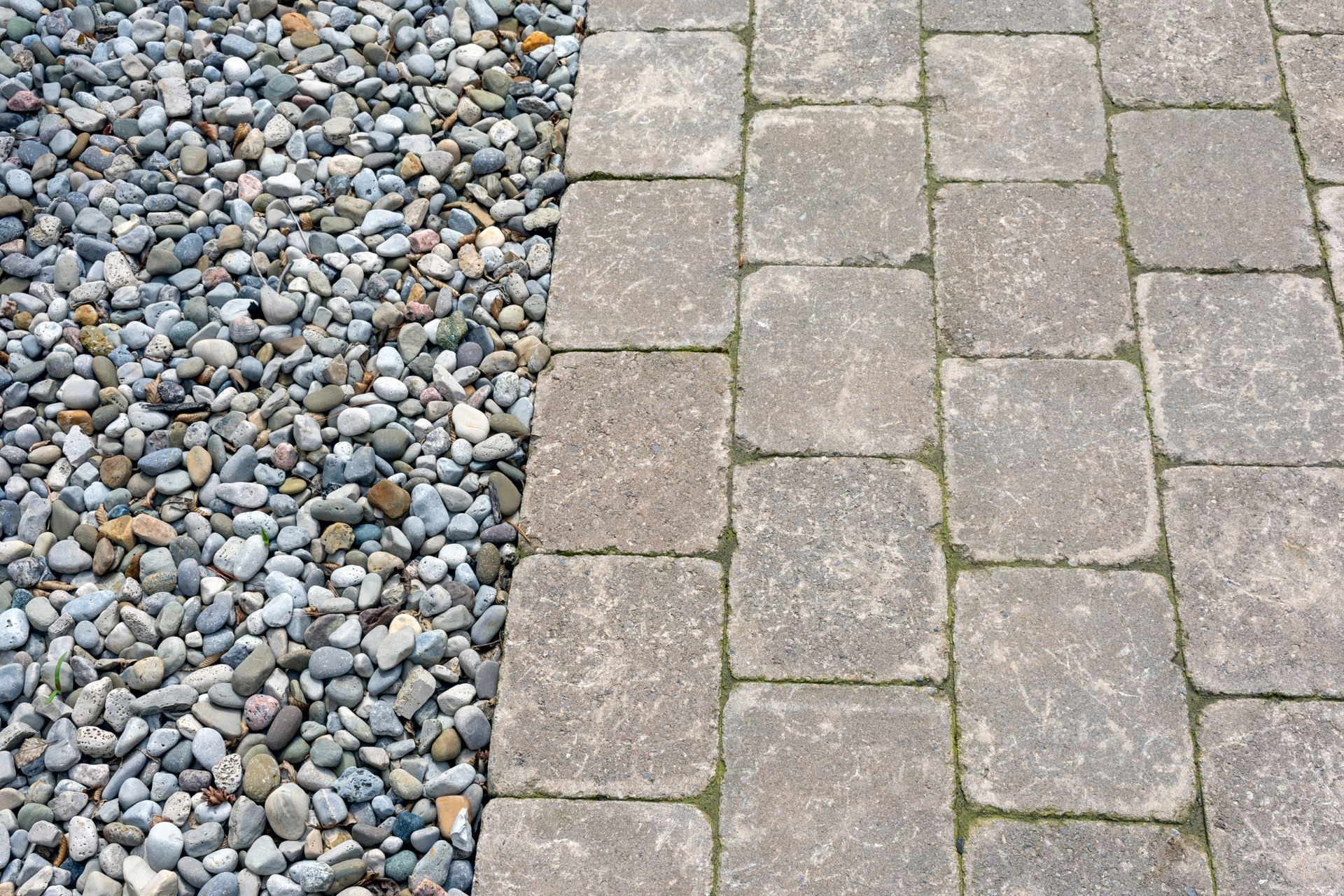 A brick walkway next to a pile of gravel