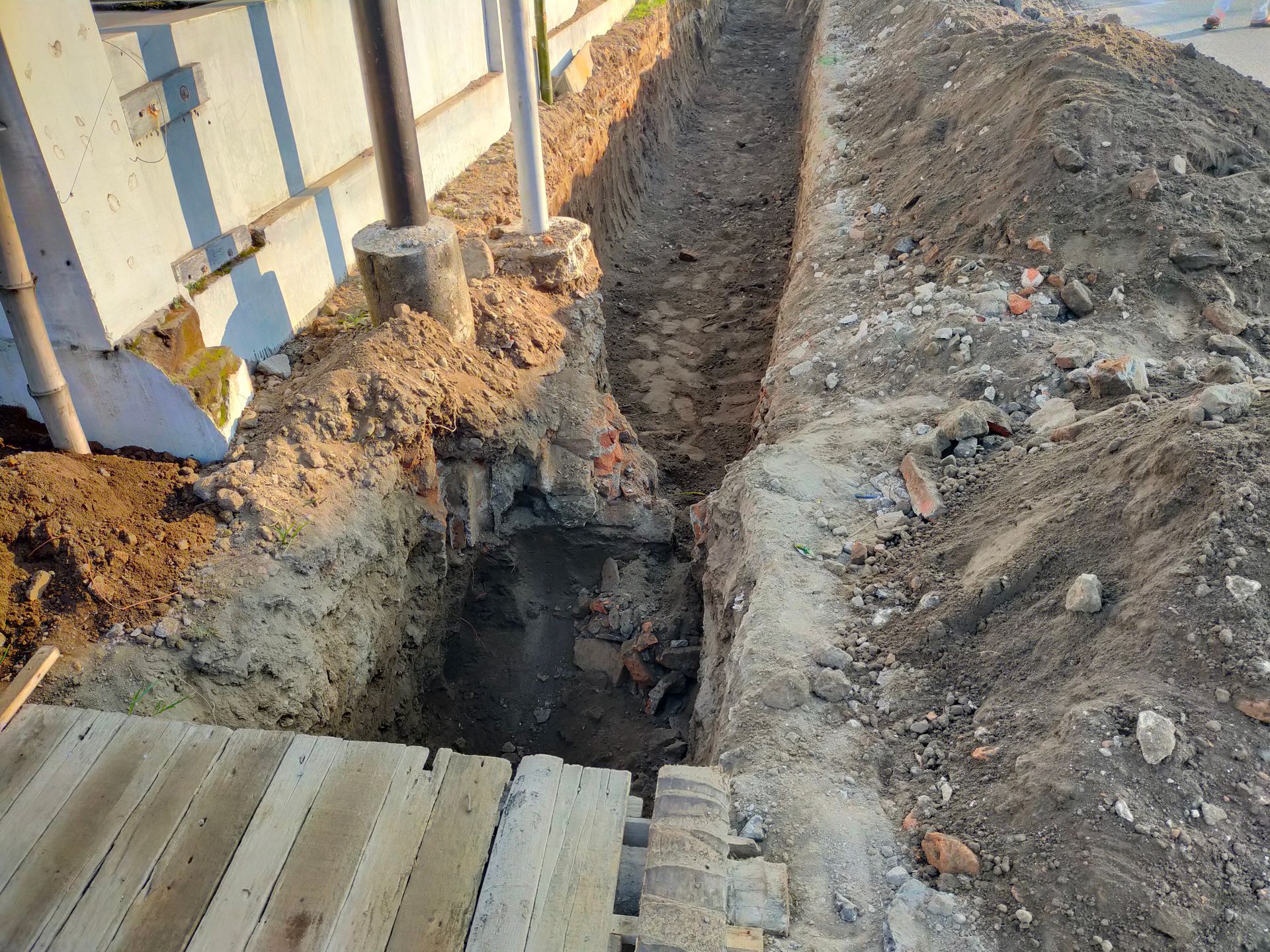 A trench is being dug in front of a building.