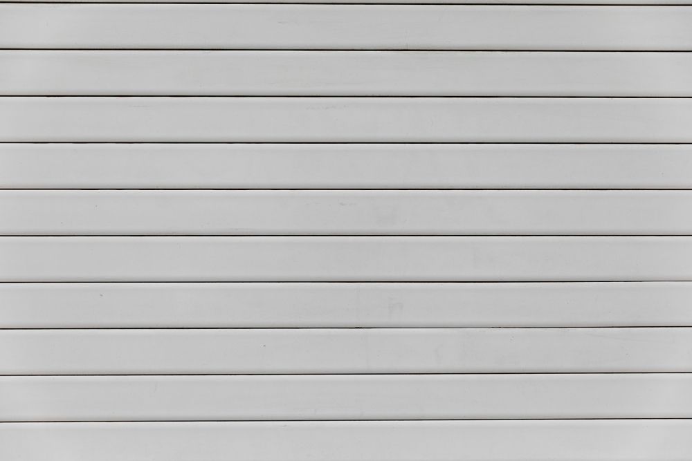 A background of horizontal, evenly spaced, off-white slats with subtle shadows between them.