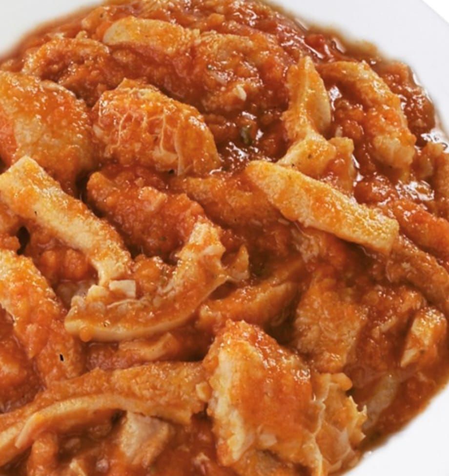 Trippa in salsa di pomodoro, servita su un piatto bianco.