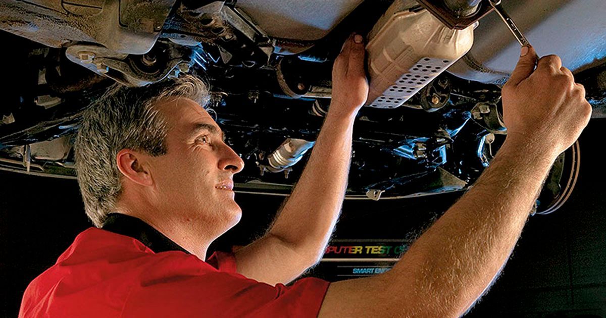 A Man in a Red Shirt is Working on a Car — Zilzie Workshop In Emu Park, QLD
