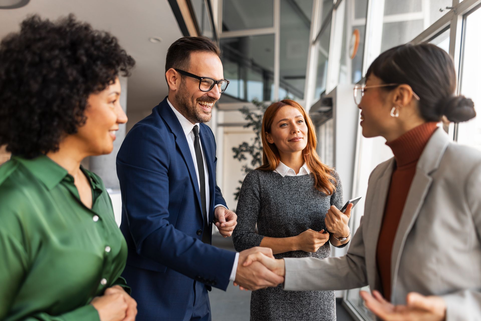 Colleagues shaking hands in a bright office during a business meeting