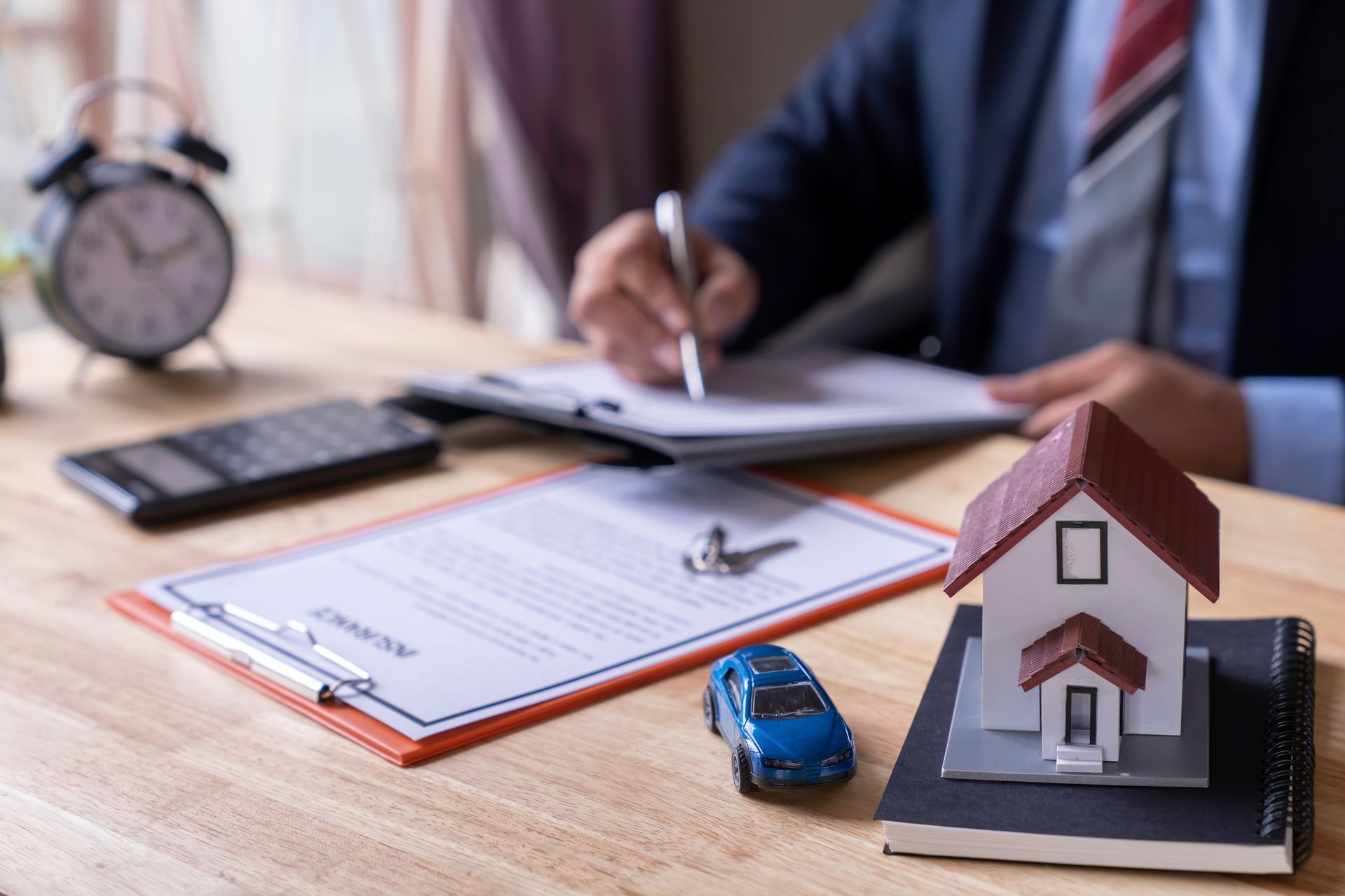 appraiesr signing document background mini house and car