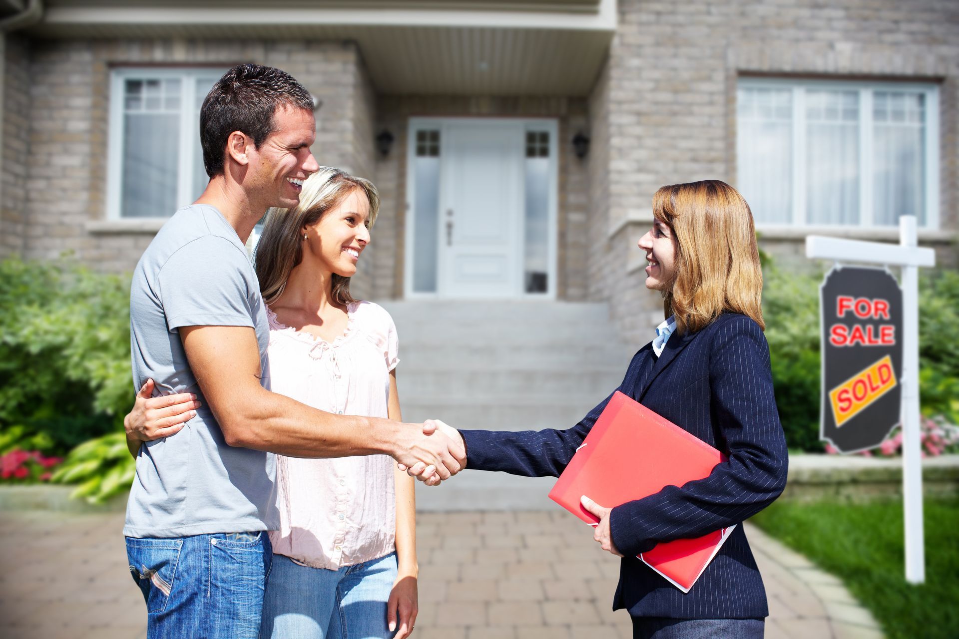 couple shaking hands with real estate agent