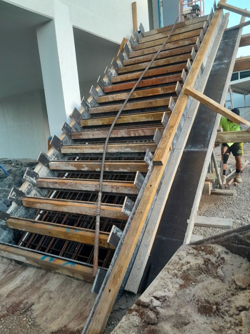 A Concrete Pathway has just been poured with poles either side of it— Bark Concreting In Ryan, QLD