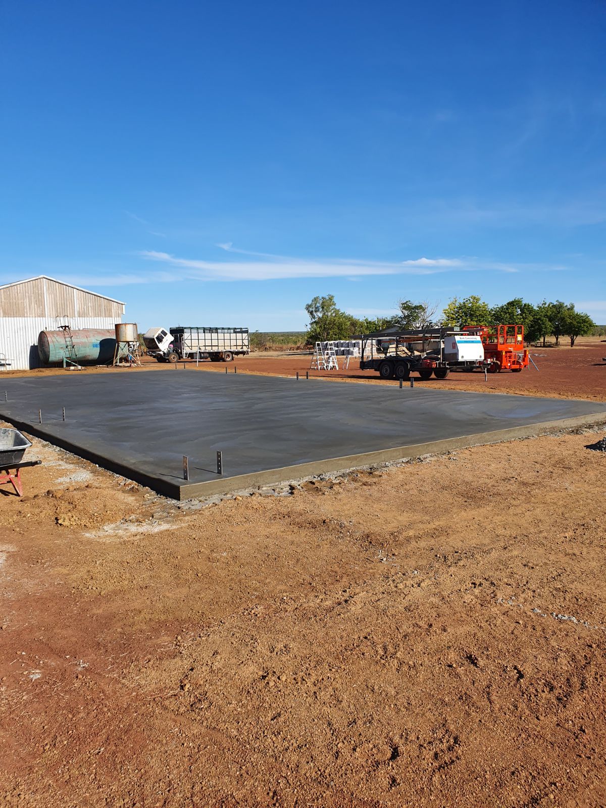 A Concrete pad for a shed is Being Built behind a shed — Bark Concreting In Ryan, QLD
